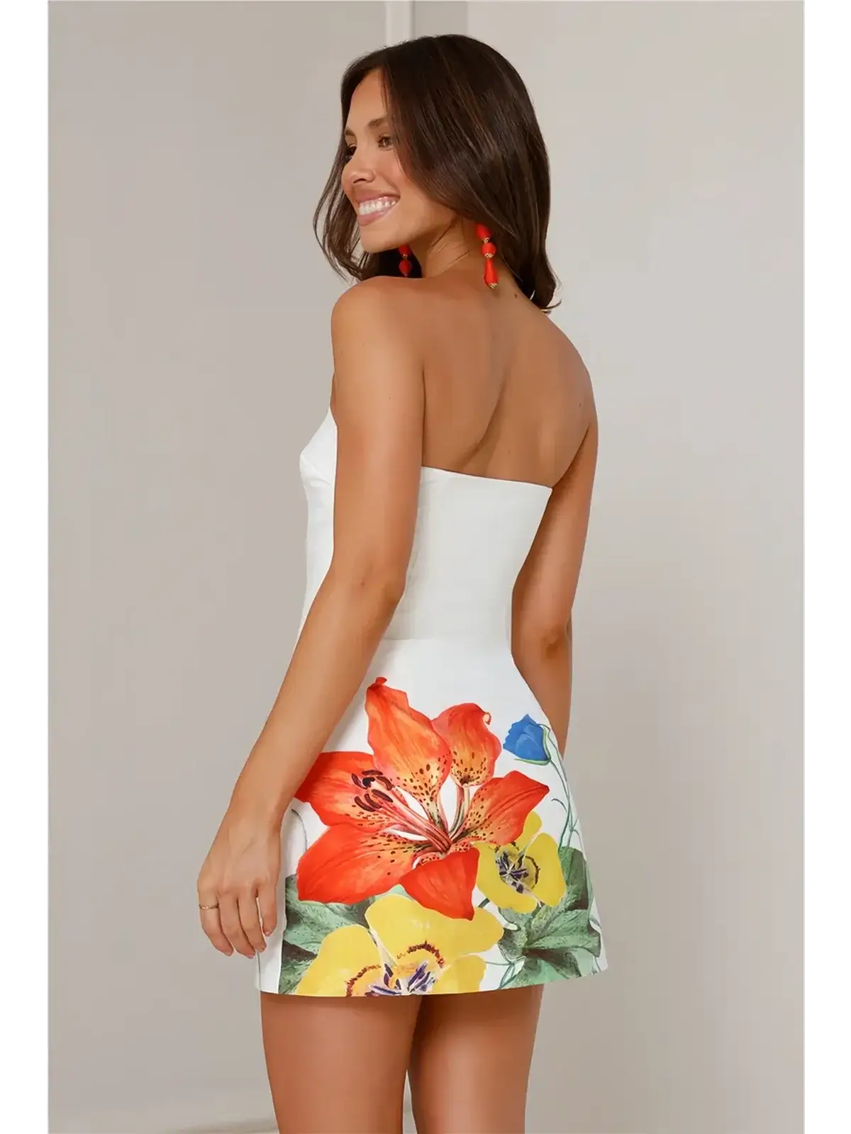 Model wearing the Petal Muse white midi dress with vibrant floral print, perfect for summer weddings and casual events.