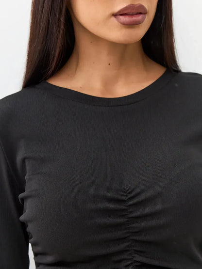 Close-up of the U-neckline and gathered ruching detail on a black long sleeve dress, perfect for evening elegance.