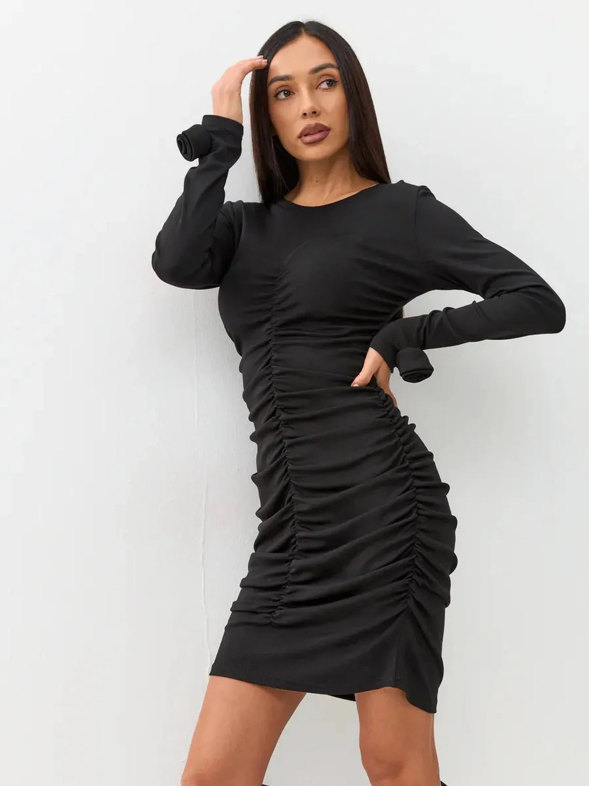 Elegant black mini dress with long sleeves and gathered ruching for a sophisticated evening look.