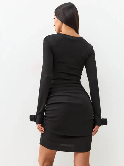 Back view of a black long sleeve mini dress with gathered ruching, perfect for evening elegance.