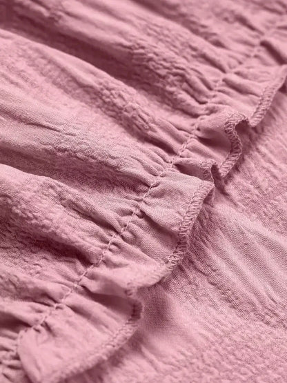 Close-up of the pink fabric showcasing soft ruching detail, perfect for summer dresses and elegant styling.