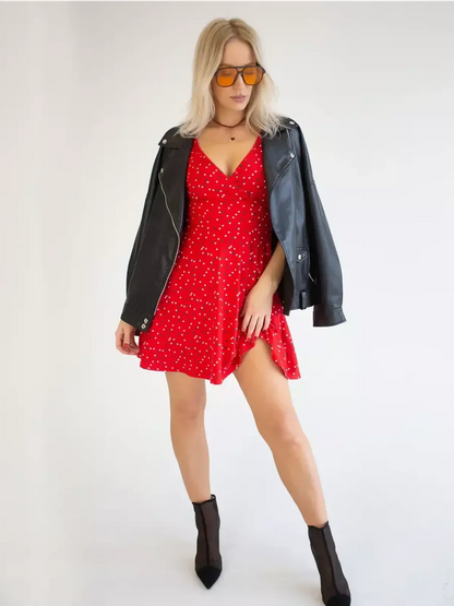 Model wearing a red polka dot mini dress with a black leather jacket and stylish sunglasses.