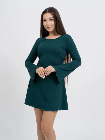 Woman wearing a long sleeve mini dress with flared sleeves in emerald green, showcasing a flattering ribbed design.