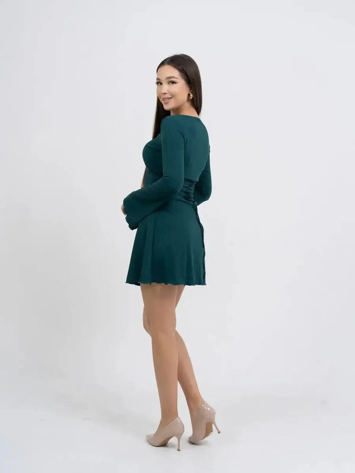 Model wearing a green long sleeve mini dress with a flared skirt, showcasing a chic and elegant silhouette.