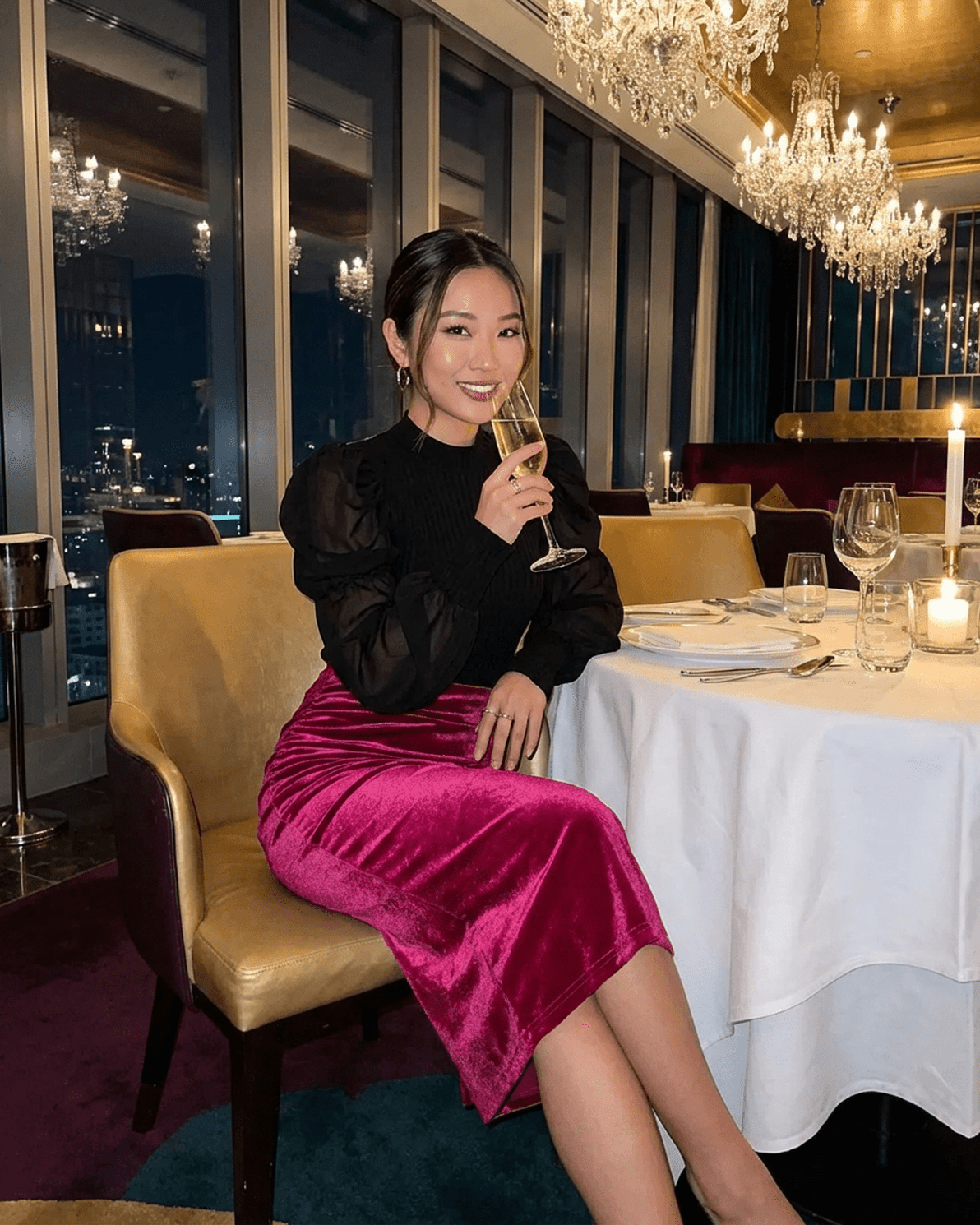 Model wearing Rosalia Midi Skirt by Slimona in a glamorous restaurant setting, highlighting its velvet texture and elegant style.