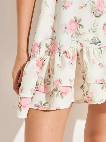 Floral mini dress featuring pink roses and flared hem, perfect for summer weddings and special occasions.