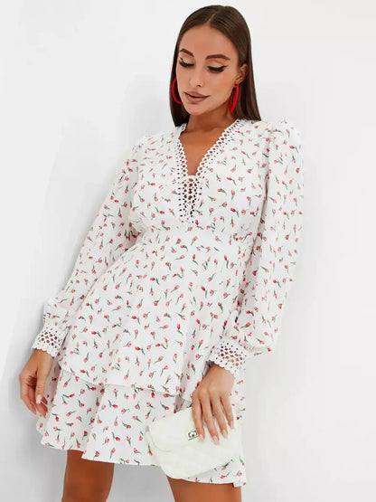 Elegant white mini dress with rosebud print and long sleeves, perfect for summer parties or wedding guest attire.