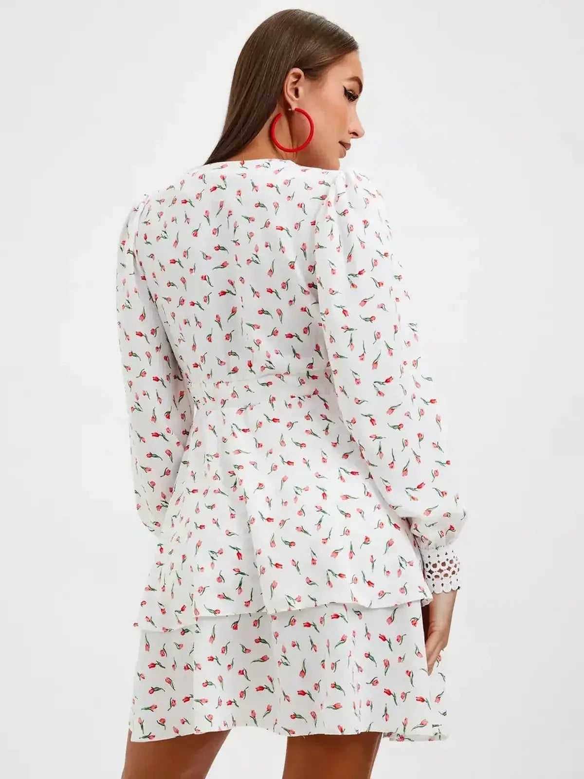 Back view of a white floral midi dress with long sleeves and a ruffled hem, perfect for summer celebrations.