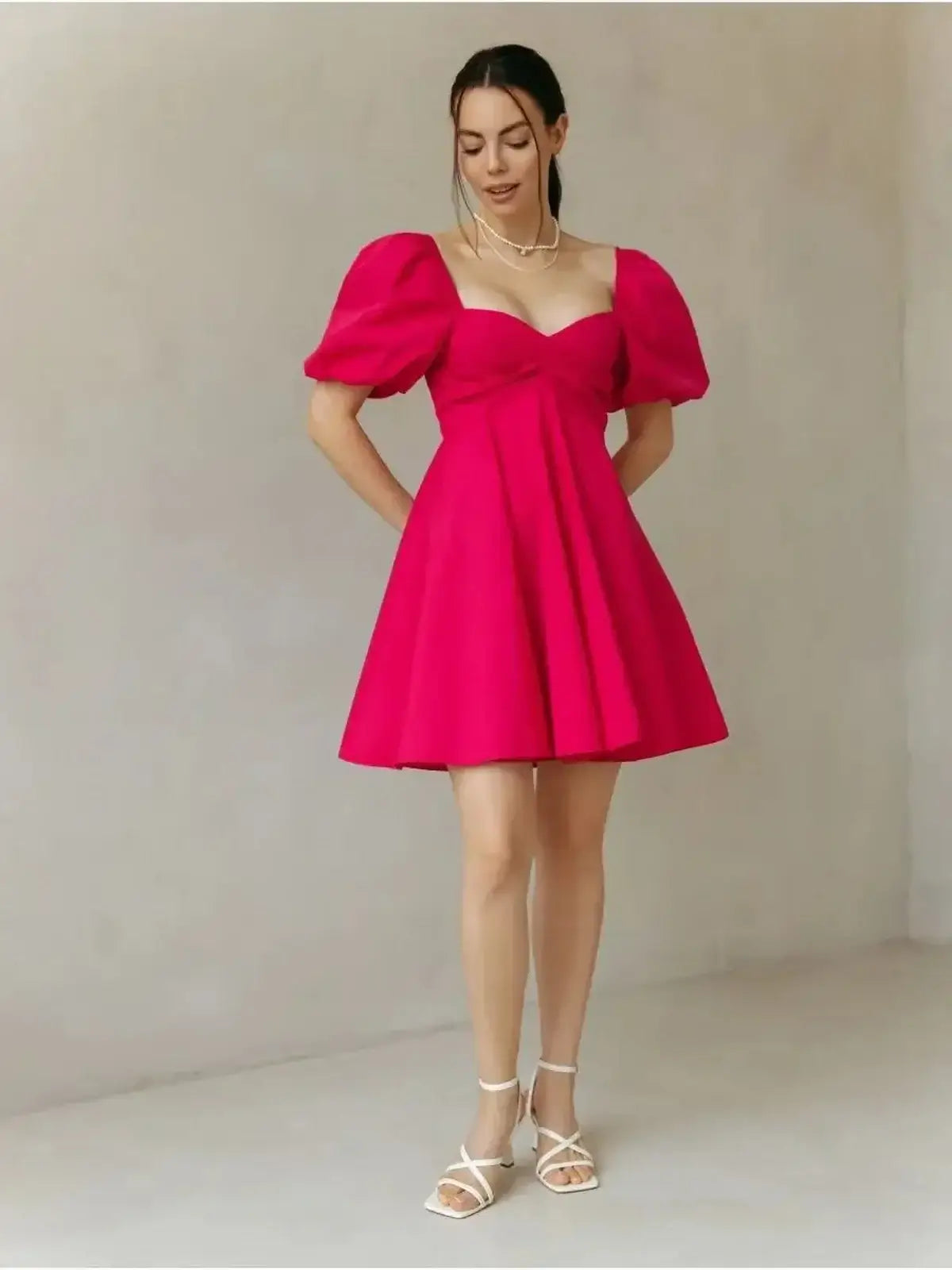 Bold pink Rose Fizz Mini Dress with puff sleeves, sweetheart neckline, and flared A-line skirt, perfect for summer events.