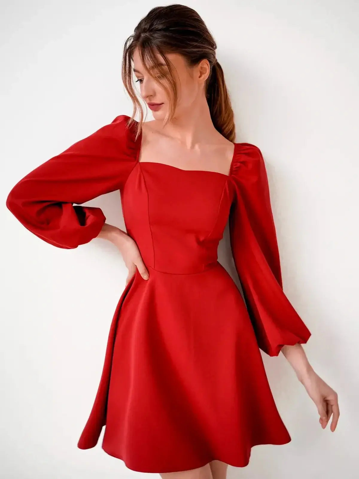 Model wearing a Ruby Flare red mini dress with puff sleeves and a square neckline, perfect for parties and special occasions.