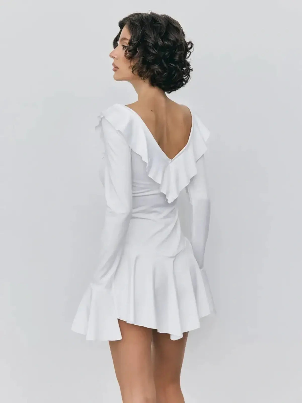 Back view of a white mini dress with ruffles, ideal for summer parties and special occasions.