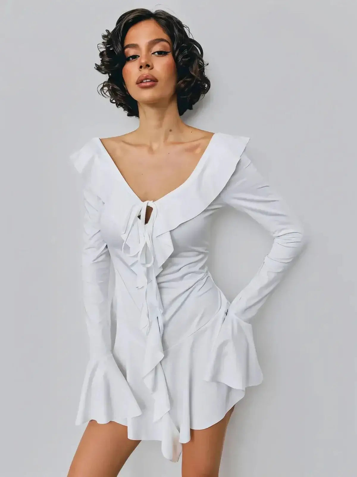 Elegant white mini dress with ruffles and deep V-neckline, perfect for summer and weddings.