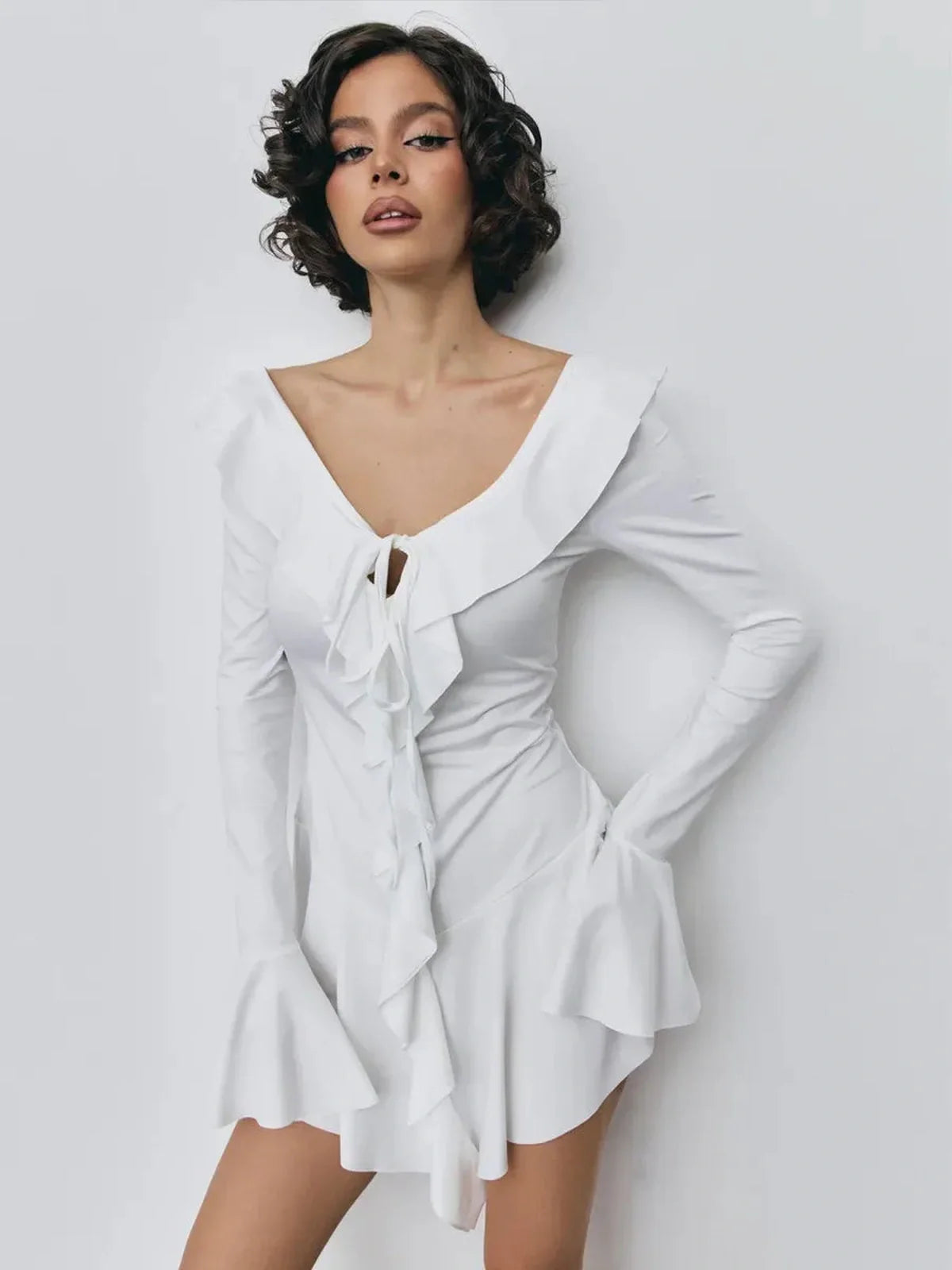 White mini dress with ruffles and deep V-neckline, stylish summer outfit for women.