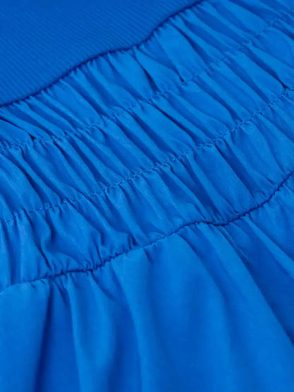 Close-up of the textured blue fabric and smocked detail of the Sapphire Tide Mini Dress, showcasing its stylish design.