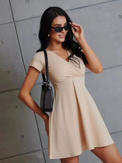 Model showcasing the Satin Glow Mini Dress, a lightweight fit-and-flare summer dress with a V-neckline.