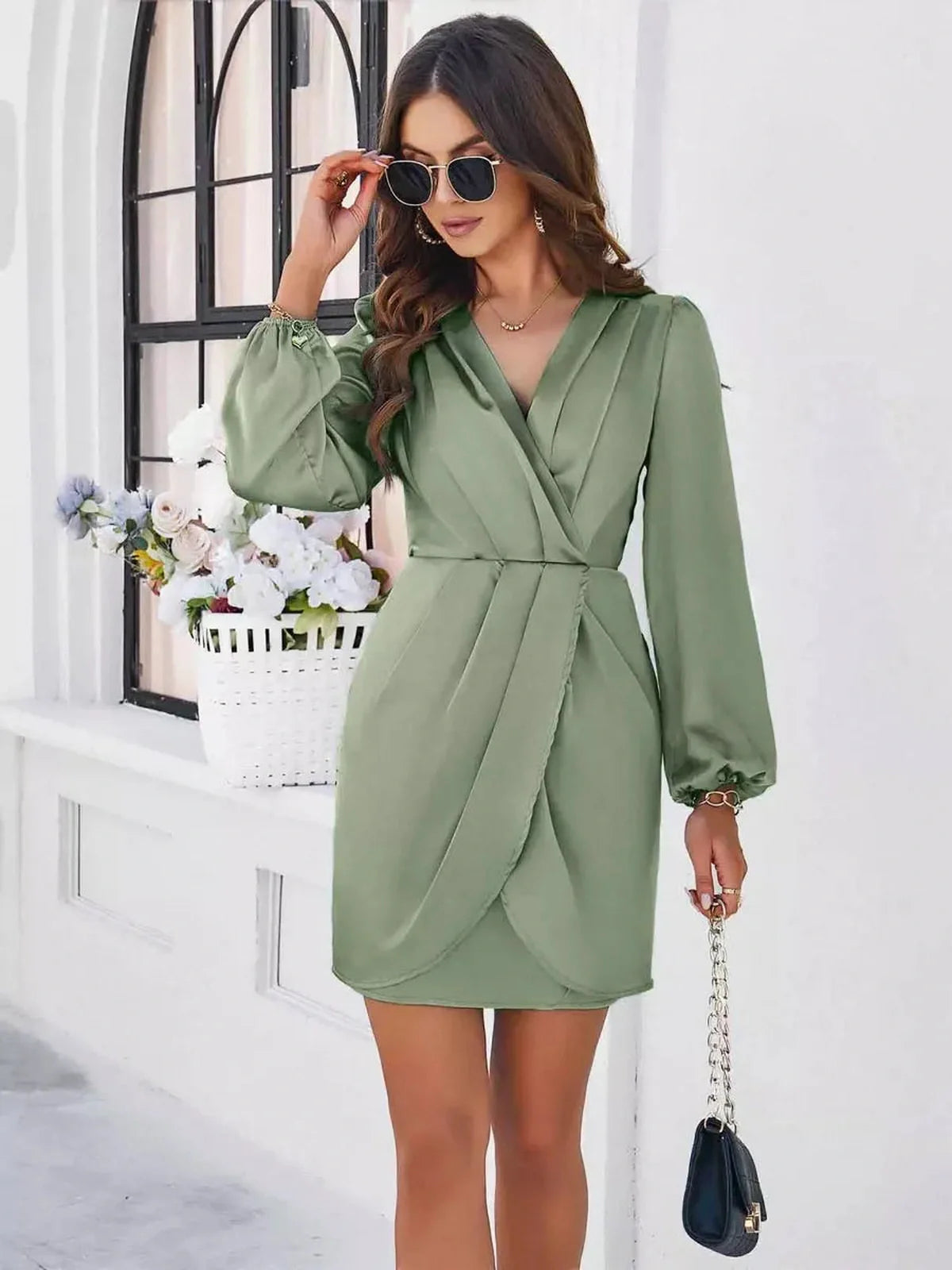 Stylish woman in a sage green Satin Wrap Mini Dress with V-neckline, perfect for wedding guest or evening occasions.