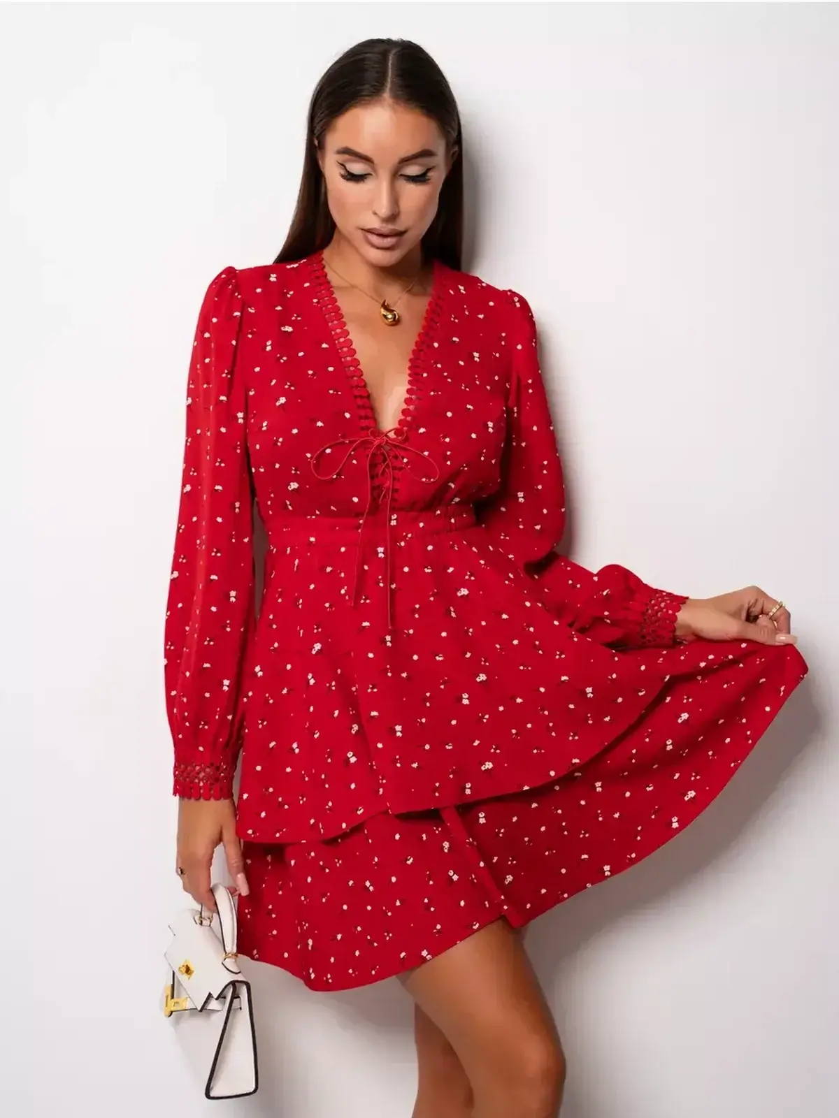 Model in a bold red mini dress with deep V-neckline and puff sleeves, perfect for wedding guest or party outfits.