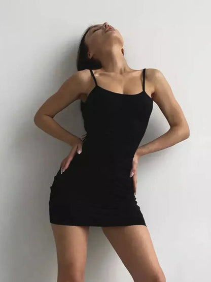 Model showcasing the Sculpt Mini black mini dress, featuring a fitted silhouette and adjustable straps for a stylish look.