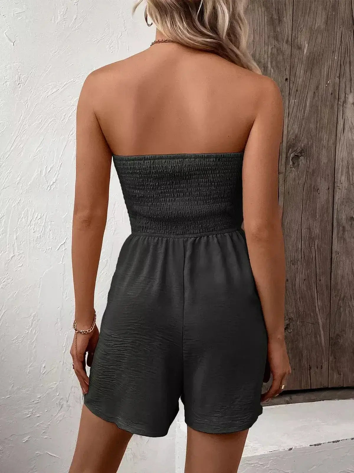 Back view of a woman in a strapless Shadowline mini dress, showcasing its smocked bodice and relaxed shorts design.