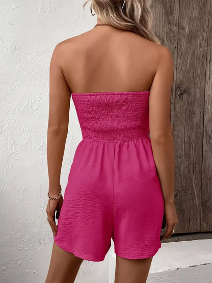 Back view of a model wearing a pink strapless Shirred Charm Mini Dress, showcasing its playful design.
