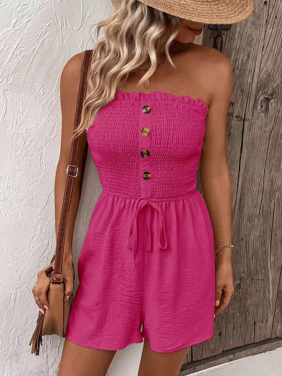 Model wearing a pink Shirred Charm Mini Dress with button detailing and a self-tie waist, perfect for summer outings.
