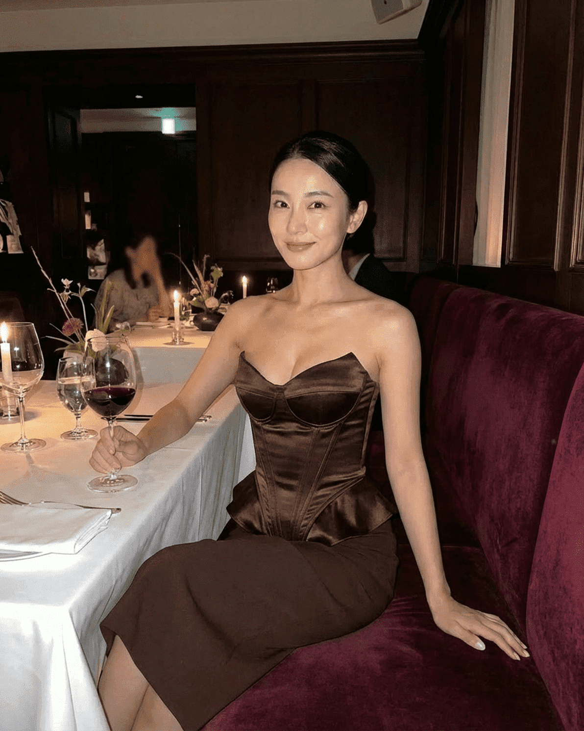 Elegant woman wearing the Sienna Corset Top by Slimona, showcasing a strapless satin design and refined brown tone.