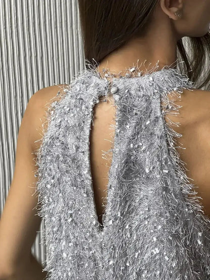 Back view of a silver halter mini dress with textural fringe and button detail, perfect for parties and weddings.