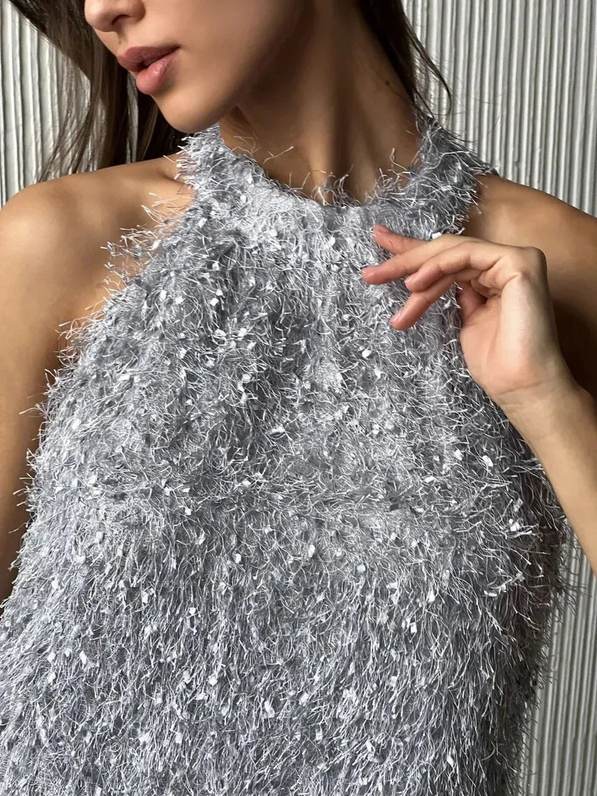 Close-up of a model in a silver halter mini dress with a fringe texture, perfect for summer and party occasions.