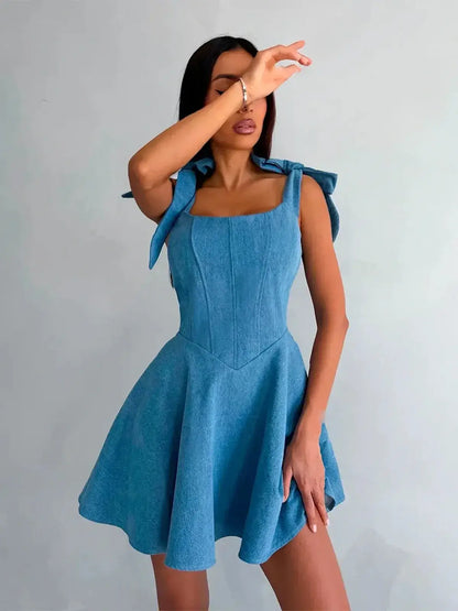 Sky Bow Corset denim dress featuring bow straps and flared skirt, perfect for summer parties or as wedding guest attire.