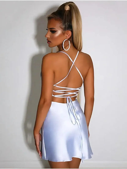 Back view of a woman wearing the Skyline Satin mini dress in sky blue, featuring crisscross lace-up ties.