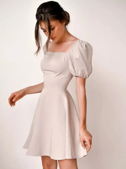 Beige mini dress with puff sleeves and square neckline, perfect for summer, weddings, and formal events.