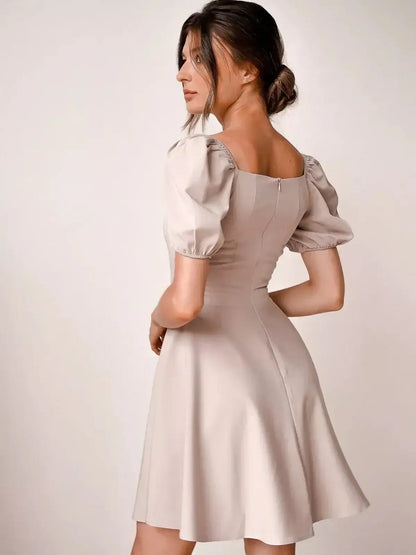 Elegant beige mini dress with puff sleeves and square neckline, perfect for wedding guests and summer events.