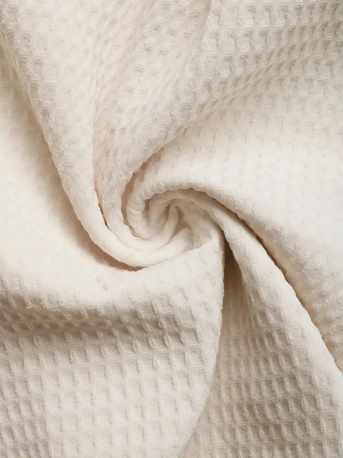 Close-up of soft, textured white fabric ideal for summer dresses and casual attire.