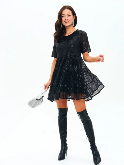 Midnight Glint sparkling black mini dress with sequins, perfect for parties and weddings, paired with over-the-knee boots.