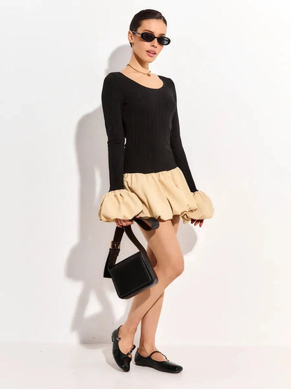Model wearing a black ribbed long sleeve mini dress with beige bubble skirt, accessorized for summer events.