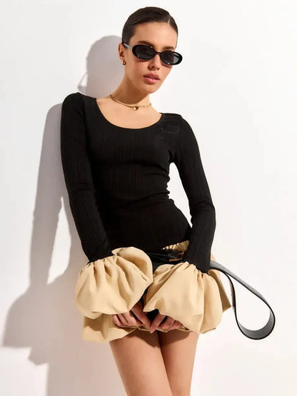 Model wearing a black ribbed long sleeve top with a beige bubble skirt, perfect for summer party dresses.