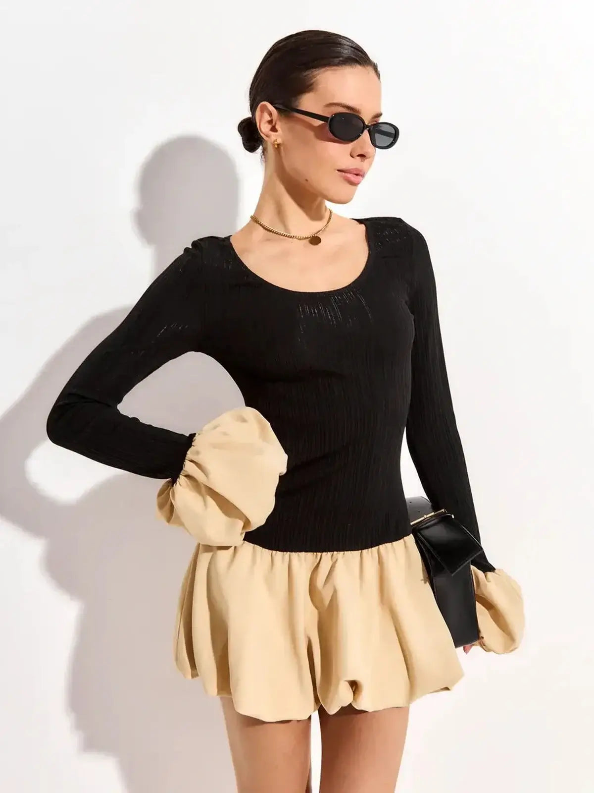 Chic Split Statement mini dress featuring a black ribbed top and voluminous beige bubble skirt.