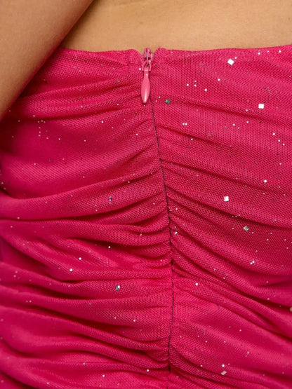 Close-up of the back zipper detail on a ruched hot pink dress with a shimmer finish.