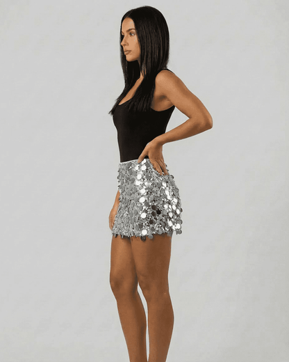 Model wearing Sterling Mini Skirt by Slimona, showcasing silver sequin hem in a stylish bodycon fit.