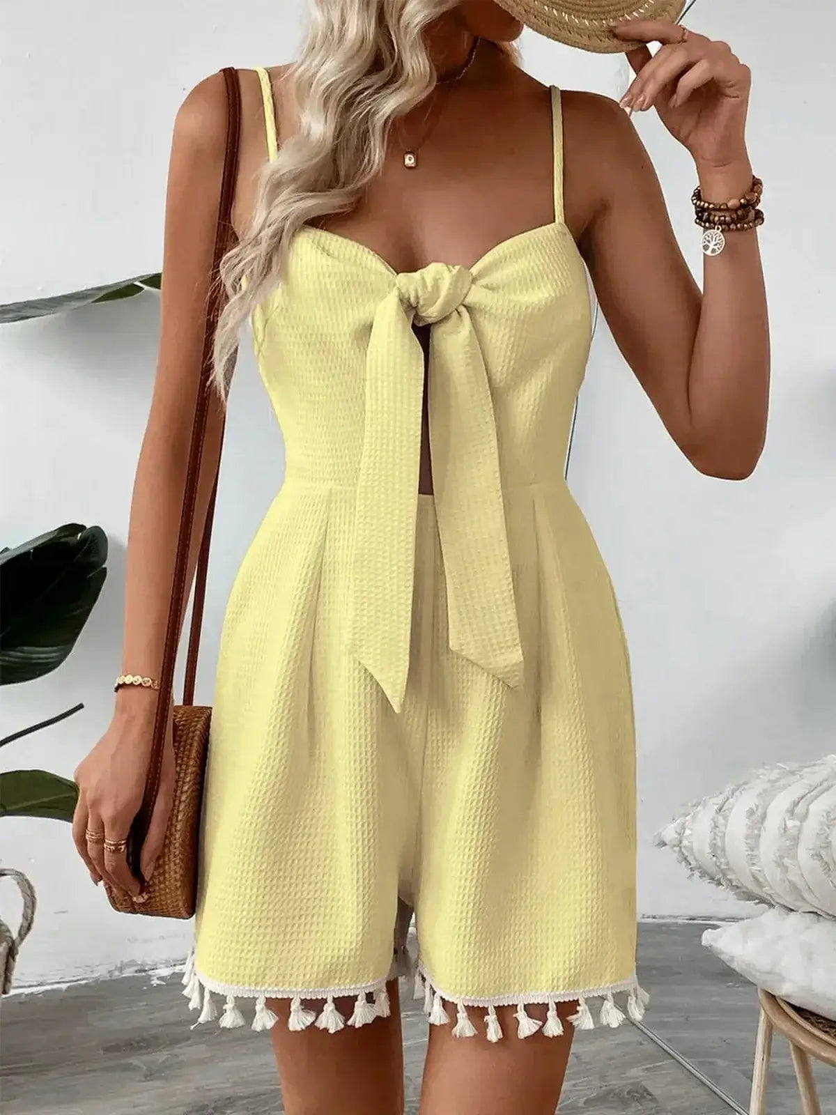 Stylish yellow mini dress with front tie detail and tassel trim, perfect for summer occasions.