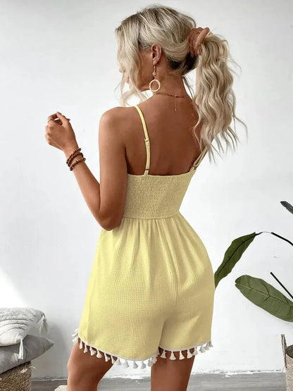 Back view of a woman in a yellow romper with tassel details, perfect for summer casual wear.