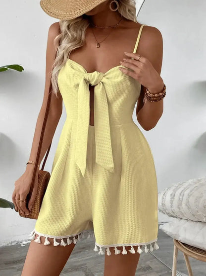 Model wearing a stylish yellow mini dress with a front tie and tassel details, perfect for summer occasions.