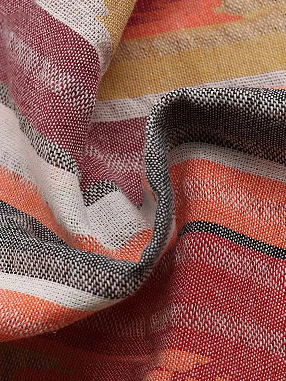 Close-up of colorful diagonal striped fabric in mandarin, pink, yellow-orange, and earthy tones for dresses.