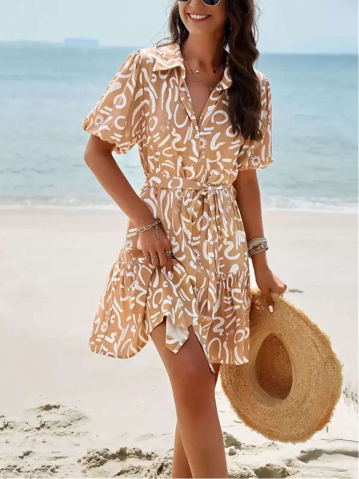 Model wearing the Sunstroke Mini Dress on the beach, featuring a collared neckline and self-tie waist.