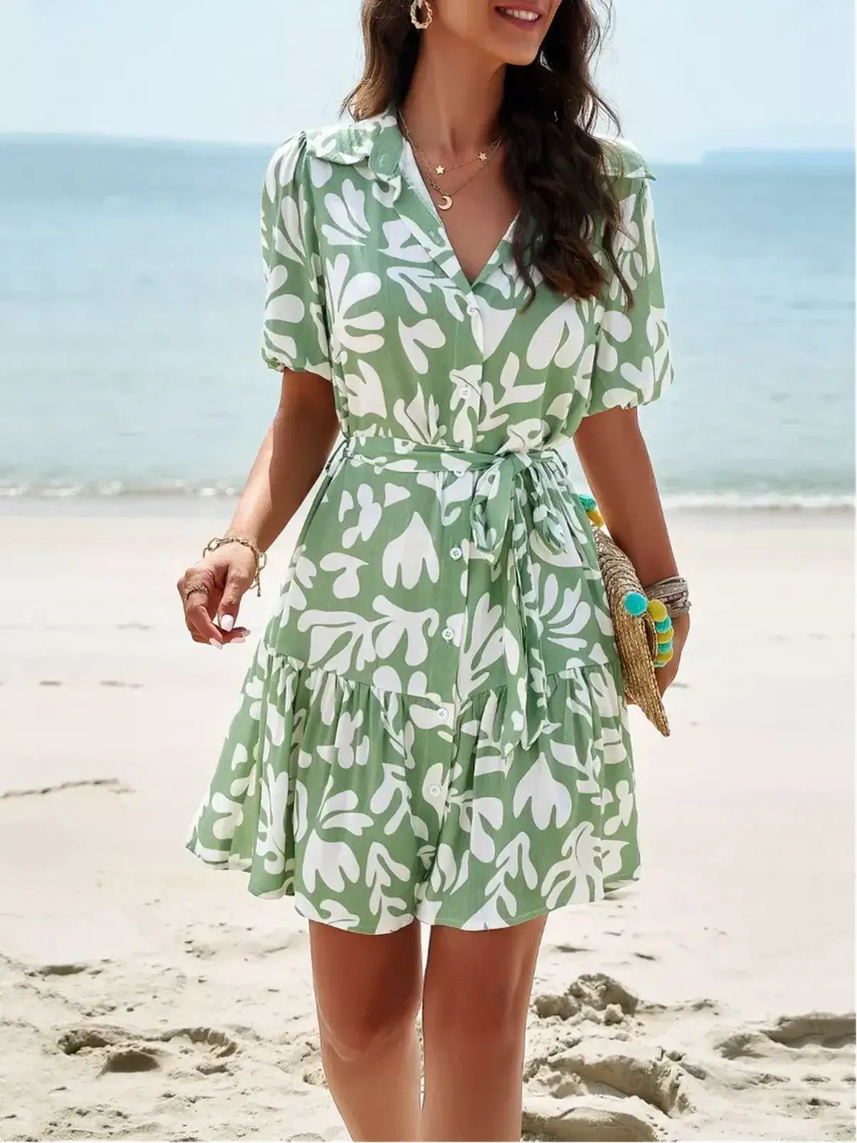 Model wearing the Tropica Breeze Mini Dress, a green floral shirt dress with a tiered silhouette, perfect for summer outings.