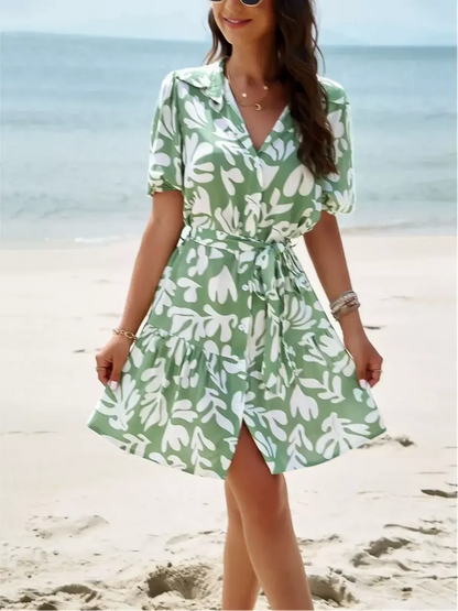 Tropica Breeze Mini Dress in soft green tropical print, perfect for summer weddings and casual outings.