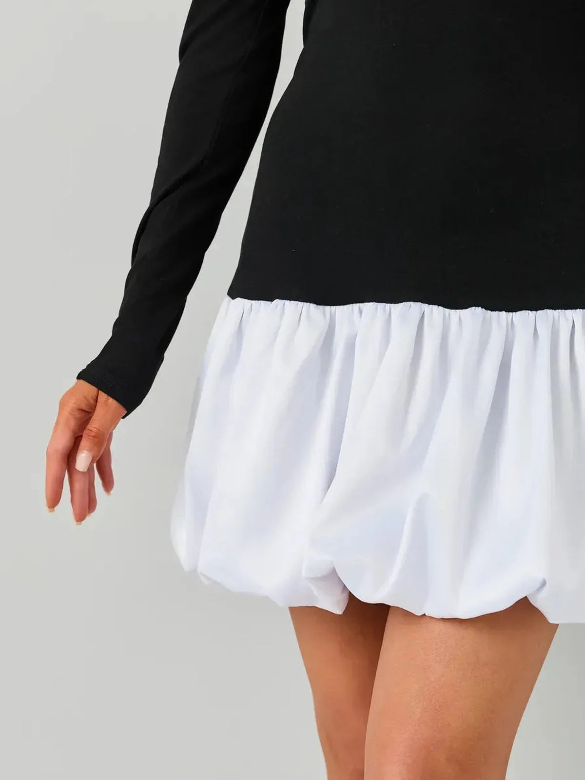 Black and white mini dress featuring long sleeves and a playful white bubble skirt.