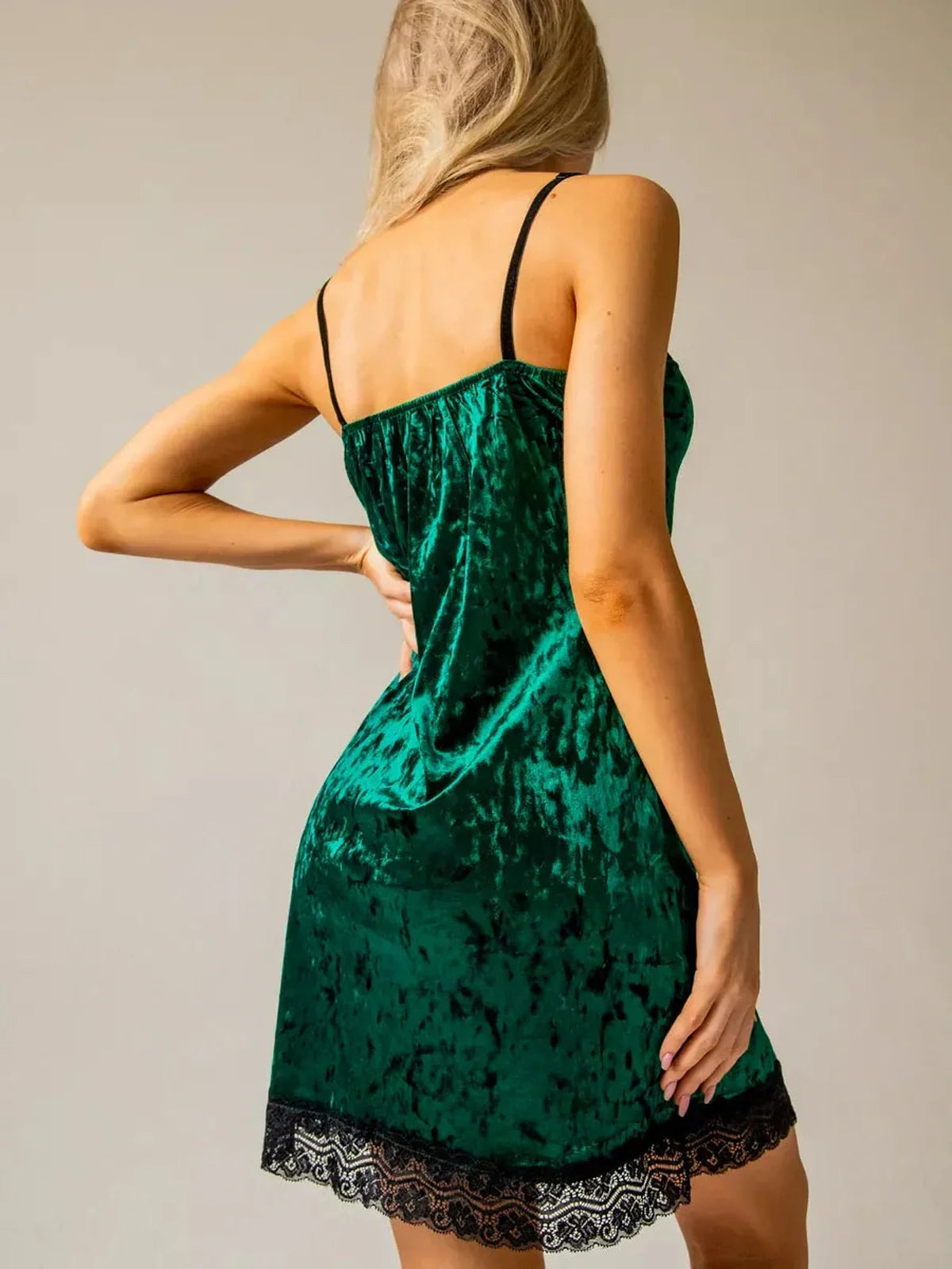Emerald green mini dress with velvet texture and black lace trim, perfect for cocktail parties and formal occasions.