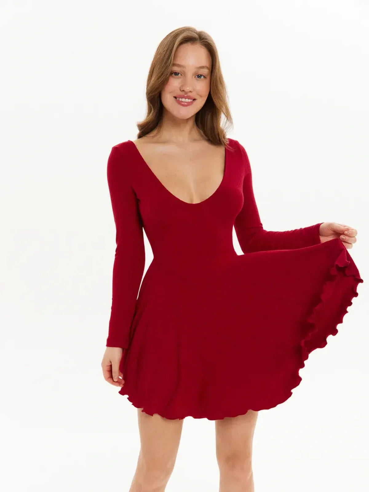 Model wearing a red Velvet Flame mini dress with a deep U-neckline and flared ruffle skirt.
