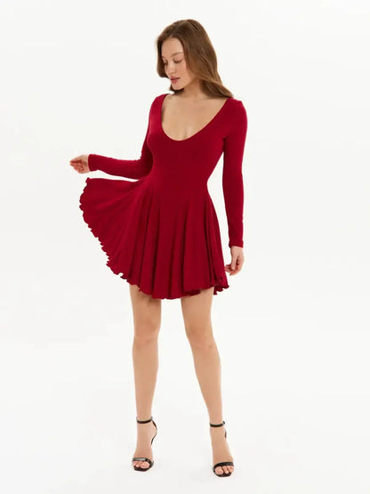 Model showcasing a red Velvet Flame mini dress with a flared skirt and long sleeves, perfect for party or wedding guest attire.